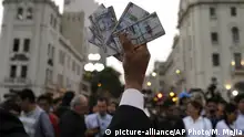 A protester holds up fake money during an anti-corruption march in Lima, Peru, in December 2017