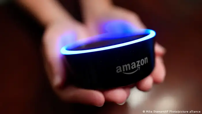 Zwei Hände halten einen Amazon Echo Dot Lautsprecher.