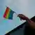 Человек держит в руке радужный флаг в знак поддержки ЛГБТ  