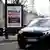 Rua com cartaz "Você quer mais SUVs nas ruas de Paris, ou menos?"
